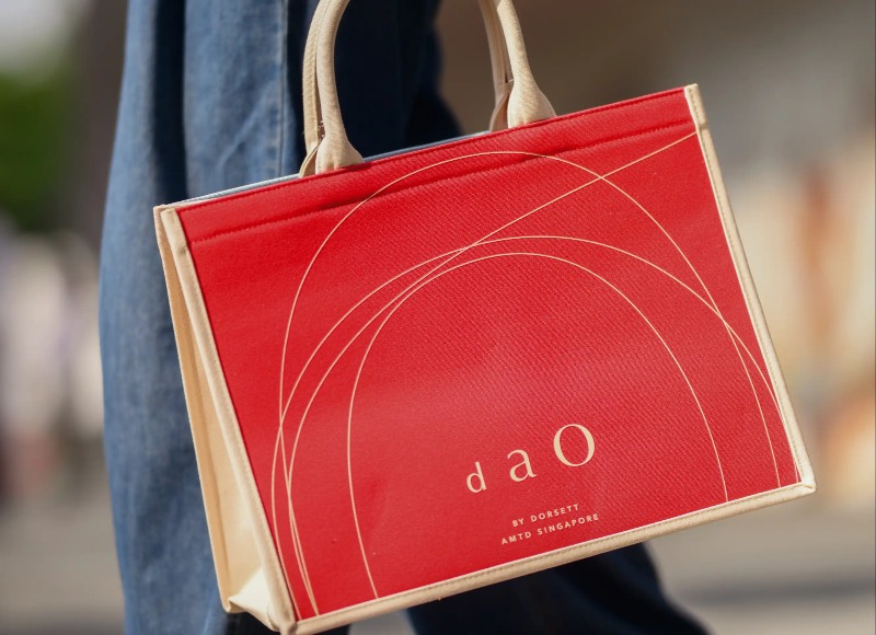 Person carrying a Dao by Dorsett AMTD Singapore branded bag.